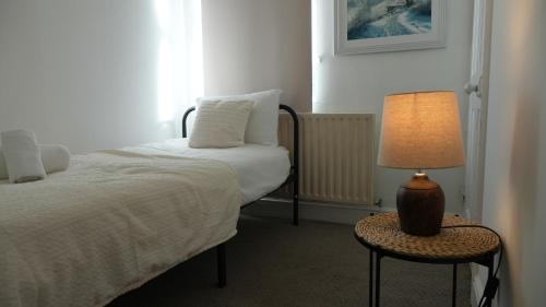 a bedroom with a bed and a lamp on a table at 3 Bed Near Coventry Arena, Contractor & Family Accommodation in Coventry