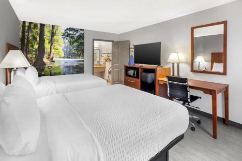a hotel room with two beds and a desk and a computer at Clarion Pointe Morrow - Atlanta South in Morrow