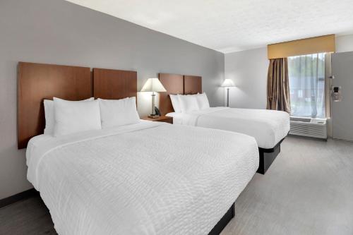 a hotel room with two beds and a window at Clarion Pointe Morrow - Atlanta South in Morrow