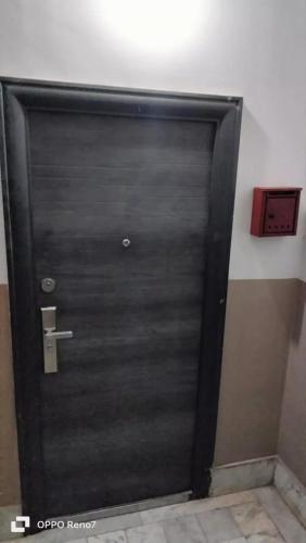 a black door in a room with a red box at Centre ville place in Tlemcen