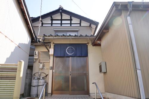 a building with a large door with birds on it at のまちのスミカ 宿 Nomachi Sumika in Kanazawa