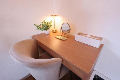 a desk with a chair and a lamp on it at のまちのスミカ 宿 Nomachi Sumika in Kanazawa