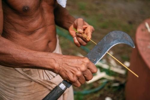 a man holding a large knife in his hands at Ganesha Homestay in Malayāttūr