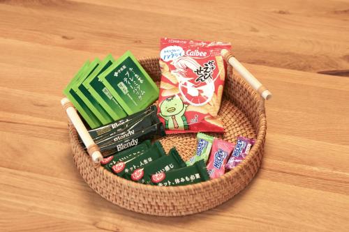a basket filled with snacks on a wooden table at のまちのスミカ 宿 Nomachi Sumika in Kanazawa