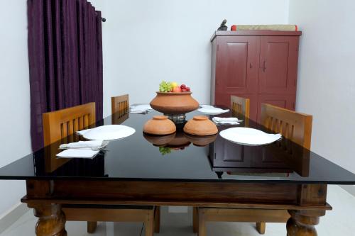 a dining room with a table and chairs at Ganesha Homestay in Malayāttūr