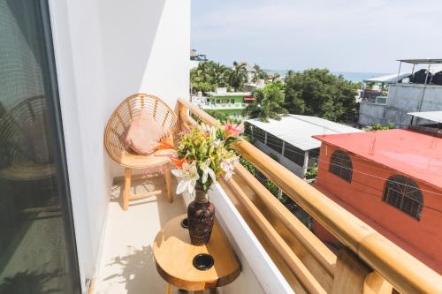 a vase of flowers on a table on a balcony at Casa Arizona in Brisas de Zicatela