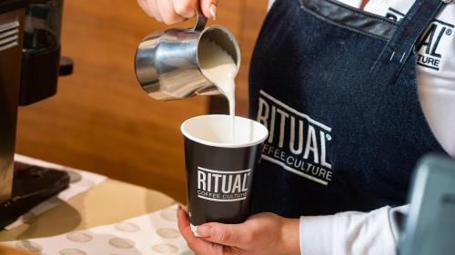 a person pouring coffee into a coffee cup at InterContinental Santiago by IHG in Santiago