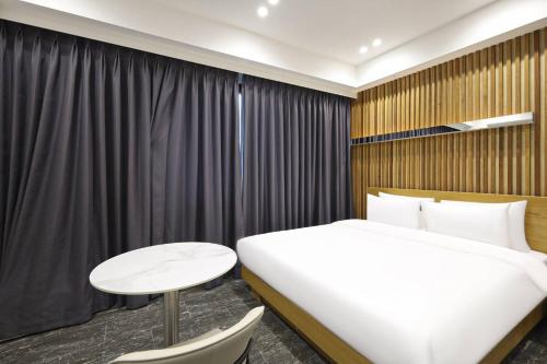 a hotel room with a bed and a table and a window at Haeundae HaeRium Hotel in Busan