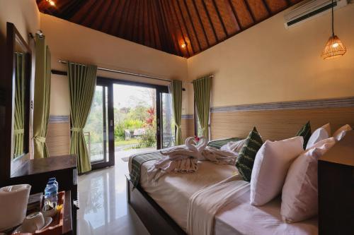 a bedroom with a bed with swans on it at WK Penida Cottage in Nusa Penida