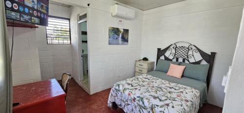 a bedroom with a bed and a dresser in it at Brisas de Jarabacoa in Jarabacoa