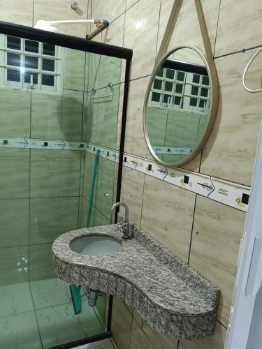 a bathroom with a sink and a mirror at Casa grande, ar em todos os quartos, cabe 3 carros in Barra do Garças