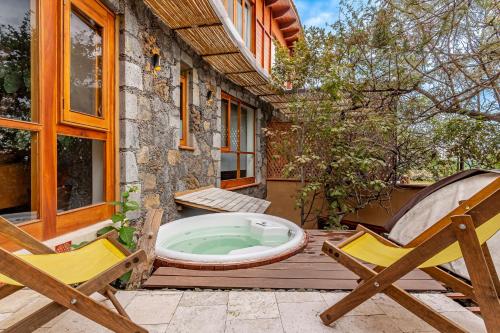 a hot tub on a deck next to two chairs at Casa Aluna - Oasis in Mountain - Premium 3 bedroom Villa in Tepoztlán with WiFi in Tepoztlán