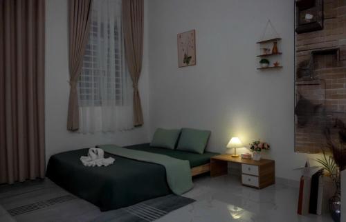a bedroom with two beds and a table with a lamp at HeavenVilla in Can Tho