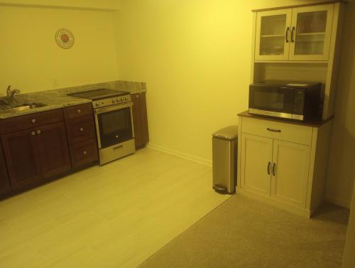 a kitchen with a stove and a microwave at Brand new apartment in seaford 