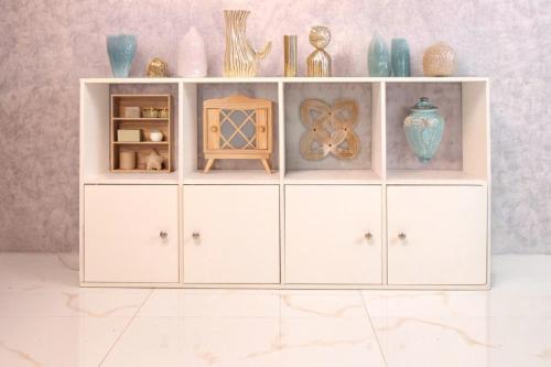 a white cabinet with vases and vases on it at HeavenVilla in Can Tho