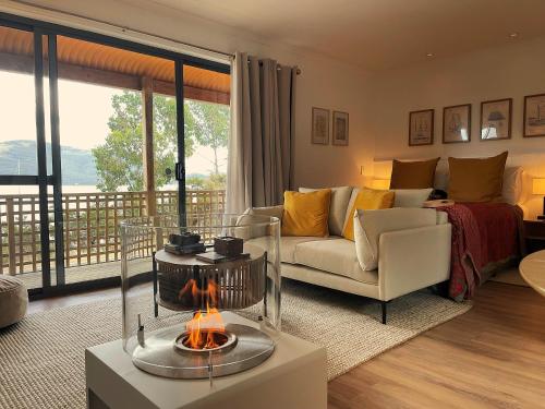 a living room with a couch and a table with a fireplace at Driftwood in Dover