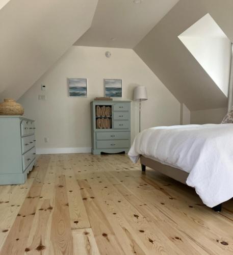a bedroom with a bed and a dresser in a attic at Luxury oceanfront escape in Neguac