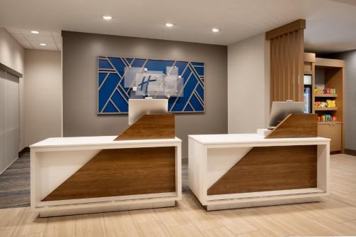 a lobby of a pharmacy with two white counters at Holiday Inn Express & Suites Fresno Airport by IHG in Fresno
