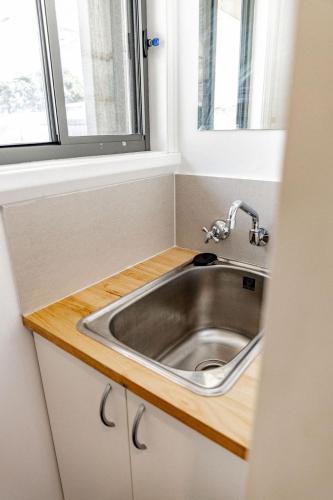 a stainless steel sink in a kitchen with a window at Total ~ Allure ~ in Bicheno