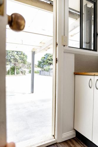 a door leading out to a patio with a view at Total ~ Allure ~ in Bicheno