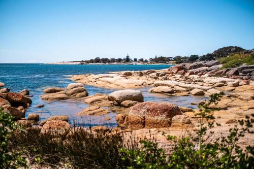 a group of rocks on the shore of a body of water at Total ~ Allure ~ in Bicheno