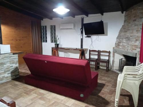 a living room with a red couch and a television at Mozitas 33 in Barra del Chuy