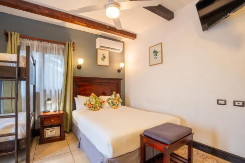 a bedroom with a bed and a stool in it at Camino Verde B&B Monteverde Costa Rica in Monteverde Costa Rica