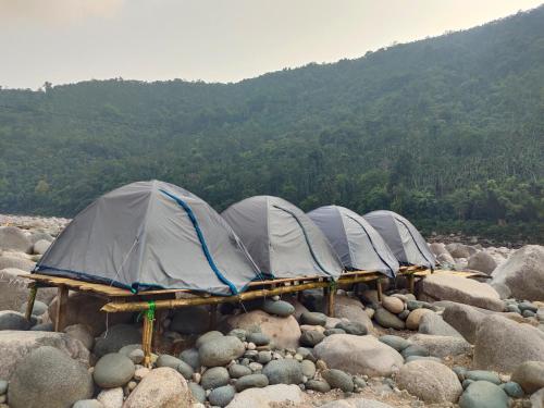 a group of tents on a bunch of rocks at River - Paradise Camps in Dawki