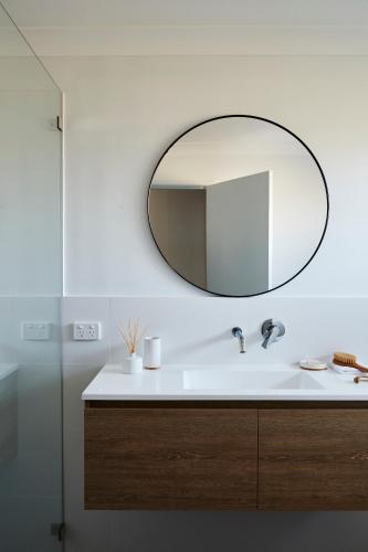 a bathroom with a sink and a mirror on the wall at Barefoot Bungalow - Beachfront Byron Bay in Byron Bay