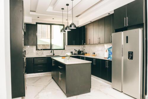 cocina con armarios de color verde oscuro y nevera en Kigali Luxury Home, en Kigali