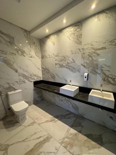 a bathroom with two sinks and a toilet at Casa Paraiso in Beberibe