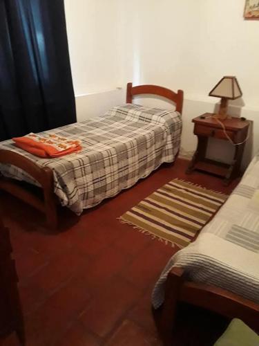 a bedroom with two beds and a table with a lamp at Cabaña Catelmo in Colalao del Valle