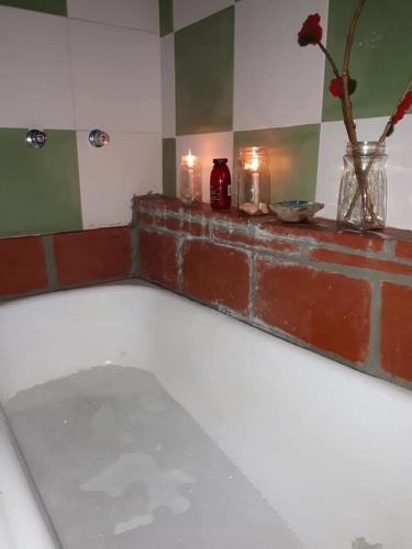 a room with candles and a brick ledge with a fireplace at Cabaña Catelmo in Colalao del Valle