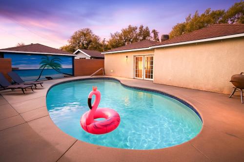 ターザーナにあるStylish 3BR Getaway plus Poolの水中の赤い白鳥のスイミングプール