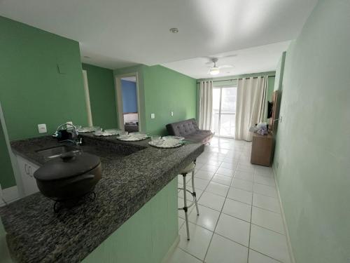 a kitchen with a counter with a sink in a room at Guarapari Residence com piscina sauna e ar in Guarapari