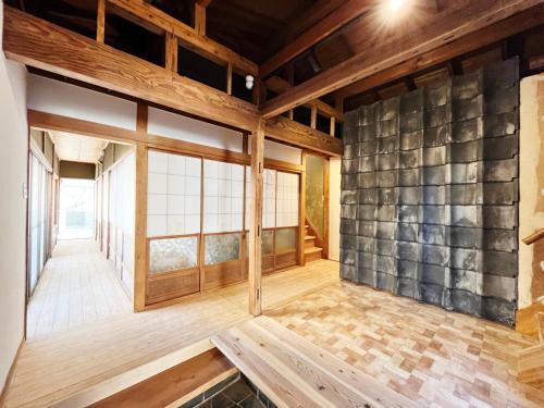 静岡市にあるGuest House NOMAYADOの石壁とウッドフロアの客室