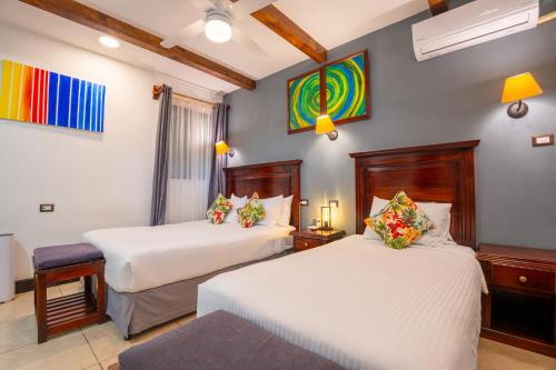 a hotel room with two beds and a table at Camino Verde B&B Monteverde Costa Rica in Monteverde Costa Rica