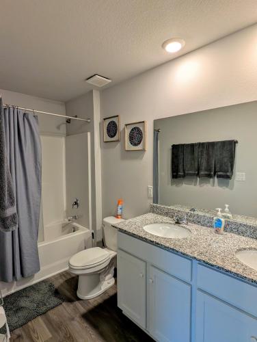a bathroom with two sinks and a toilet and a tub at Modern Comfort in Des Moines