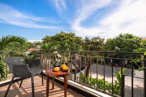a balcony with two chairs and a table with fruit on it at Numa Villa Near Old Town Hoi An in Hoi An