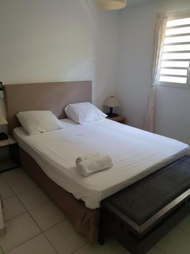a bedroom with a large bed with white sheets at Appartement 2 pièces proche centre Commercial Galléria in Le Lamentin
