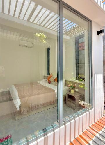 a glass window of a bedroom with a bed at Seaside Mui Ne Hotel in Mui Ne