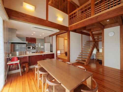 Una cocina y un comedor con mesa y sillas de madera. en New OPEN！ Luxury Seaside Villa 神湊　駐車場無料　海辺の別荘　, en Kōnominato