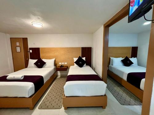 a hotel room with two beds and a flat screen tv at Hotel Posada Maria Sofia in Cholula