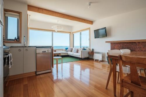 a kitchen and living room with a couch and a table at Awesome Beach House Bicheno in Bicheno