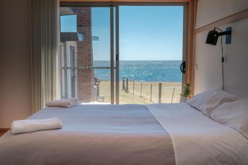 Un dormitorio con una cama grande con vista al mar. en Awesome Beach House Bicheno, en Bicheno