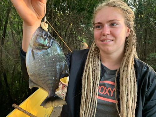 a woman holding a fish on a spear at Amazon Private Tours Jungle Lodge in Manacapuru