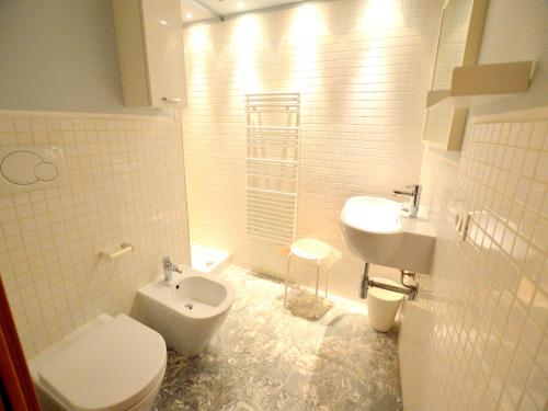 a white bathroom with a toilet and a sink at Charming Mansion in Lucca in Lucca