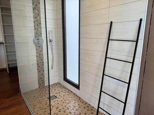 a shower with a glass door in a bathroom at Villa Californienne proche Nouméa in Païta