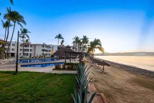 a view of a beach with palm trees and a resort at Vista Vallarta All Suites On The Beach in Bucerías