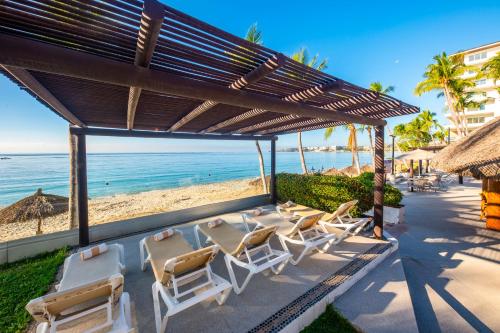 a group of lounge chairs on the beach at Vista Vallarta All Suites On The Beach in Bucerías